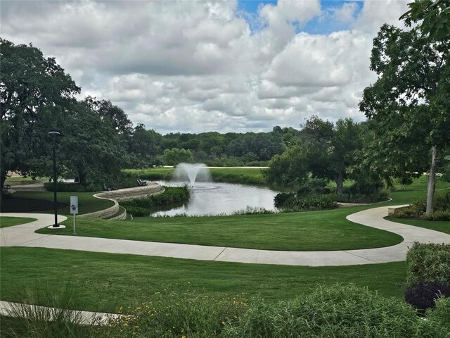 view of community with a water view and a yard