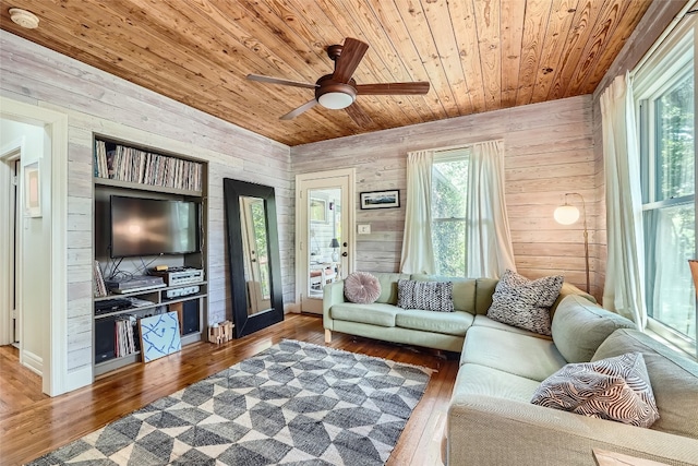 living room with wood ceiling, hardwood / wood-style flooring, wooden walls, and ceiling fan