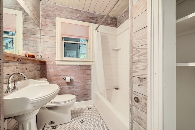 bathroom featuring wood walls, toilet, shower / tub combo with curtain, tile patterned floors, and wooden ceiling