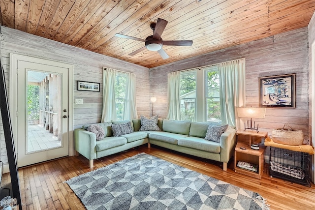 living room with wooden walls, ceiling fan, hardwood / wood-style floors, and wooden ceiling