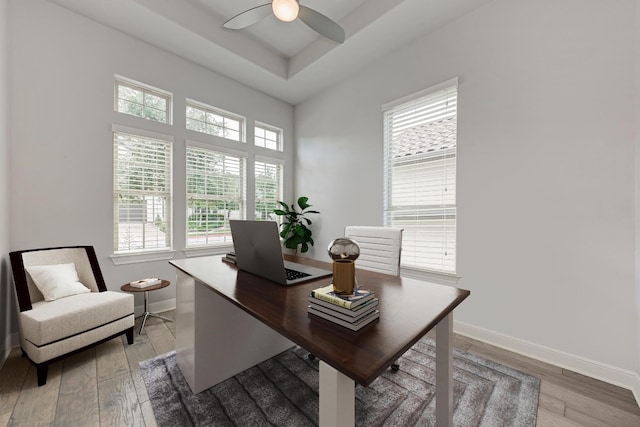 office with light hardwood / wood-style floors, a healthy amount of sunlight, and ceiling fan