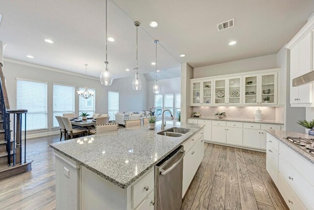 kitchen featuring sink, stainless steel dishwasher, decorative backsplash, and a kitchen island with sink