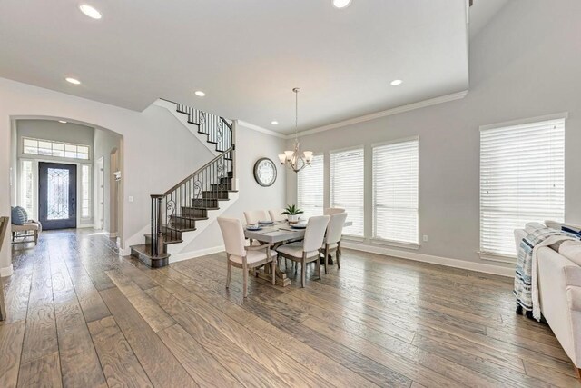 dining space with a notable chandelier, hardwood / wood-style floors, and ornamental molding