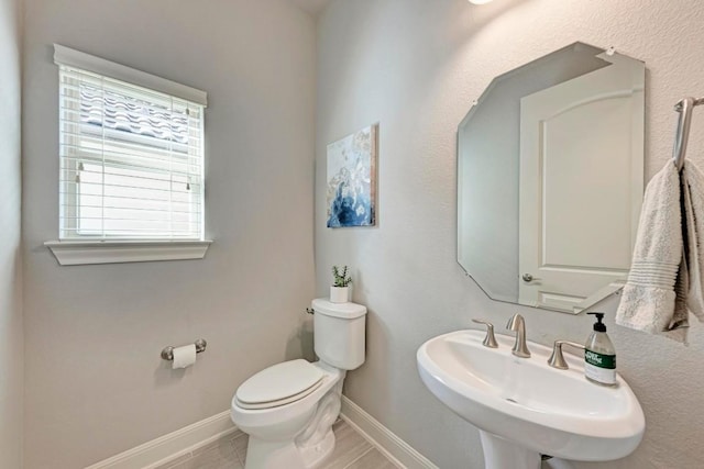 bathroom featuring tile patterned flooring, toilet, and sink