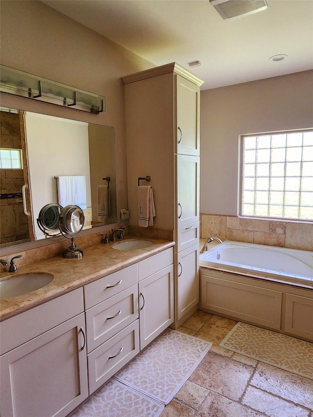 bathroom featuring vanity and a bath