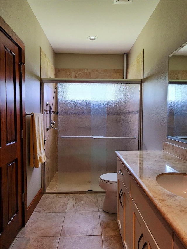 bathroom with toilet, a shower with door, and vanity