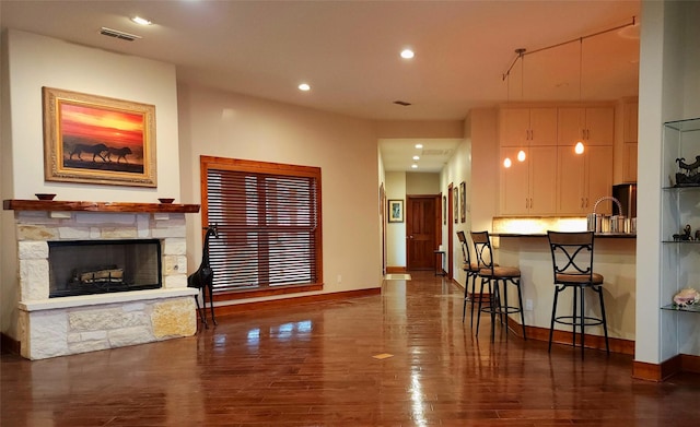 living room with dark hardwood / wood-style flooring and a fireplace