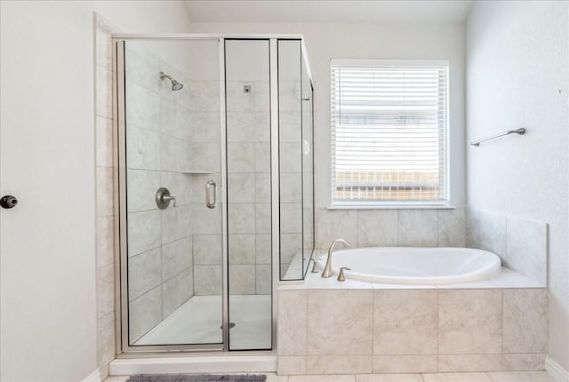 bathroom featuring a shower stall, a bath, and baseboards