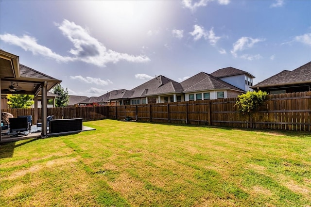 view of yard featuring outdoor lounge area, ceiling fan, and a patio