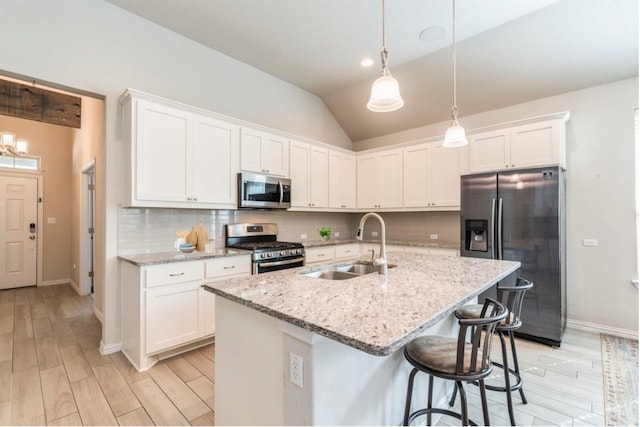 kitchen with white cabinetry, sink, backsplash, lofted ceiling, and appliances with stainless steel finishes