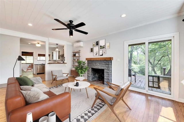 2108 River Hills Rd, Austin, TX 78733 - living area with an AC wall unit, hardwood / wood-style flooring, a ceiling fan, a stone fireplace, and recessed lighting