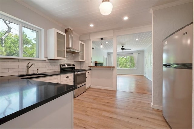 2108 River Hills Rd, Austin, TX 78733 - kitchen with stainless steel appliances, wall chimney range hood, dark countertops, light wood-type flooring, and tasteful backsplash