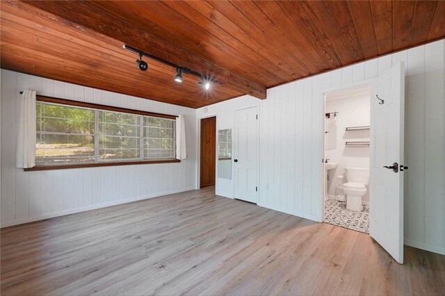 2108 River Hills Rd, Austin, TX 78733 - unfurnished bedroom featuring wood finished floors, wood ceiling, rail lighting, ensuite bath, and wood walls