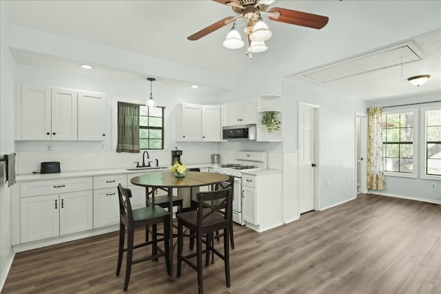 2108 River Hills Rd, Austin, TX 78733 - kitchen with white gas range, stainless steel microwave, a sink, dark wood-type flooring, and white cabinets