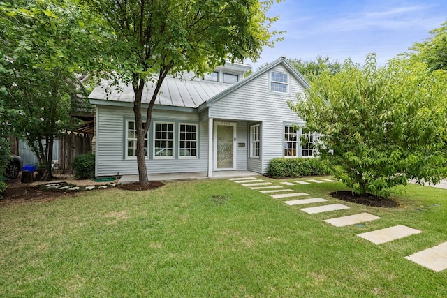 view of front of house with a front yard, a standing seam roof, and metal roof