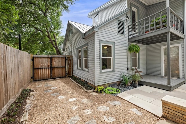 1202 E 30th St, Austin, TX 78722 - view of property exterior featuring a balcony, a gate, fence, a standing seam roof, and metal roof