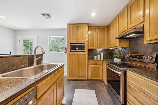 kitchen featuring appliances with stainless steel finishes, tasteful backsplash, and sink