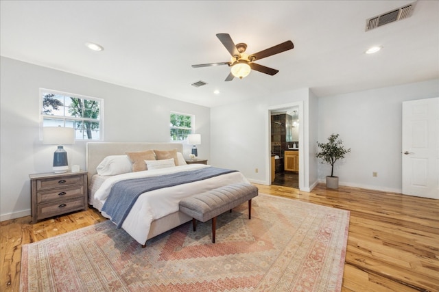 bedroom with ensuite bath, light wood-type flooring, and ceiling fan