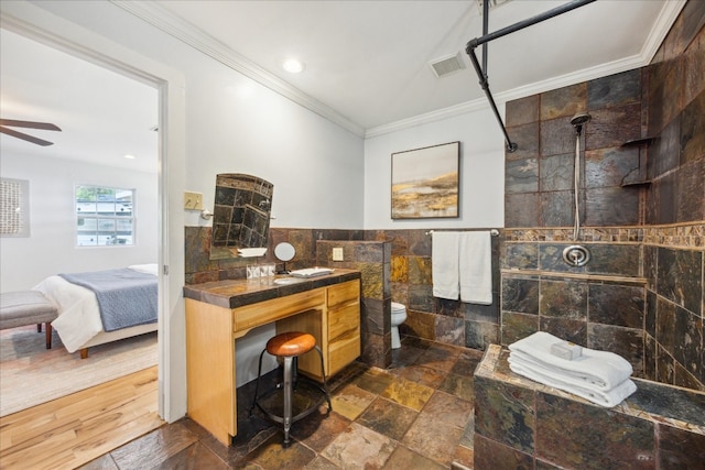 bathroom with tile walls, tile patterned floors, toilet, vanity, and ceiling fan