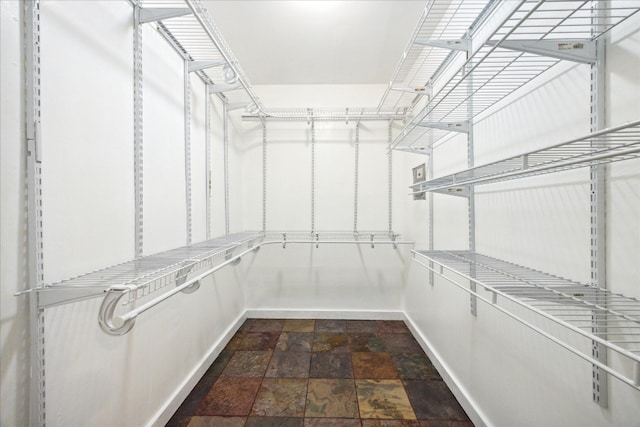 spacious closet featuring dark tile patterned flooring