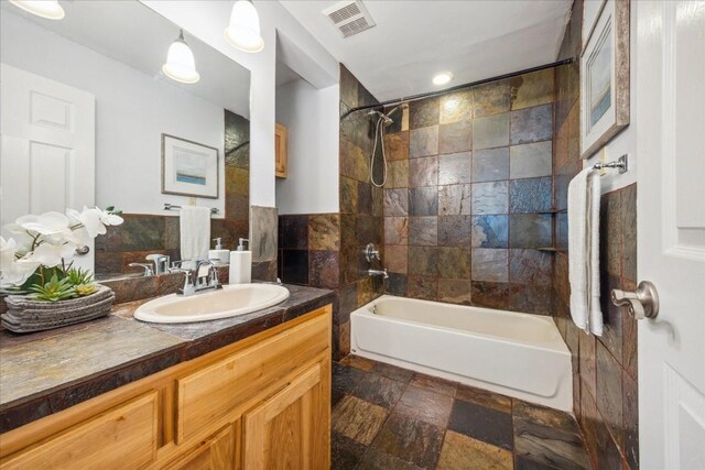 bathroom with tiled shower / bath combo, vanity, and tile patterned floors