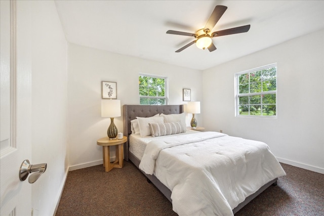 carpeted bedroom featuring multiple windows and ceiling fan