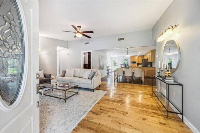 living room featuring light hardwood / wood-style floors and ceiling fan