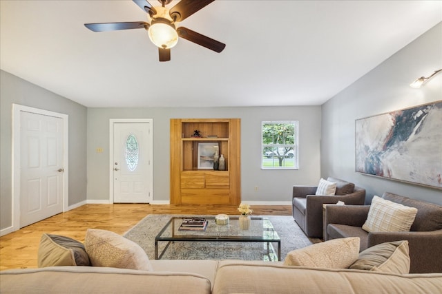 living room featuring light hardwood / wood-style flooring and ceiling fan