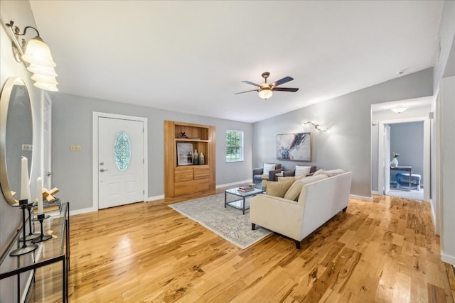 living room featuring ceiling fan, light hardwood / wood-style flooring, and lofted ceiling