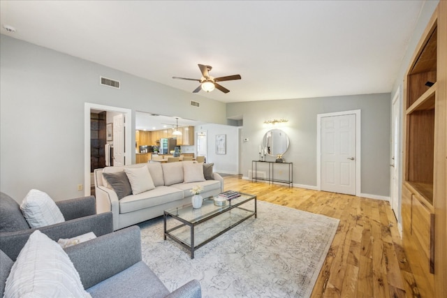 living room featuring ceiling fan and light hardwood / wood-style flooring