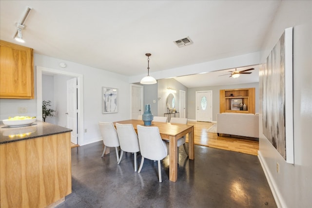 dining area with wood-type flooring, rail lighting, and ceiling fan