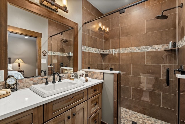 bathroom featuring a shower with door and vanity