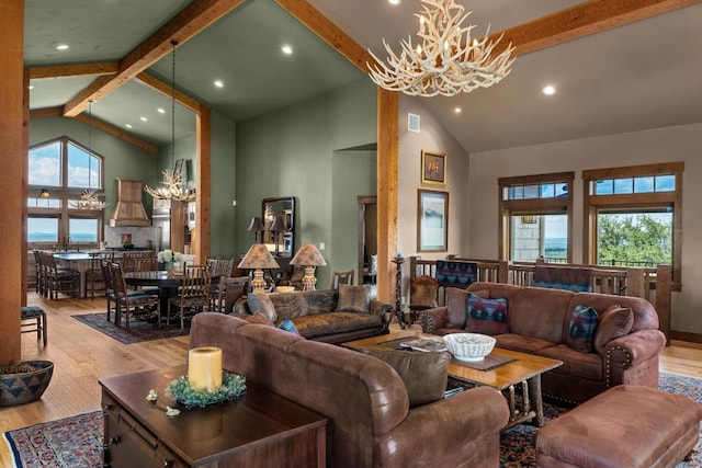 living room with high vaulted ceiling, beamed ceiling, light hardwood / wood-style flooring, and a notable chandelier