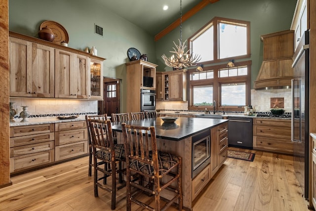 kitchen with a center island, backsplash, light hardwood / wood-style flooring, and stainless steel appliances