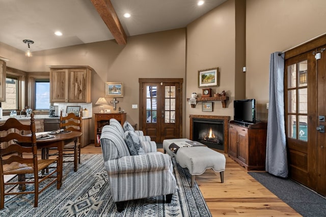 living room featuring beam ceiling, hardwood / wood-style flooring, high vaulted ceiling, and plenty of natural light