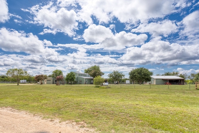 view of yard with an outbuilding, a pole building, and fence