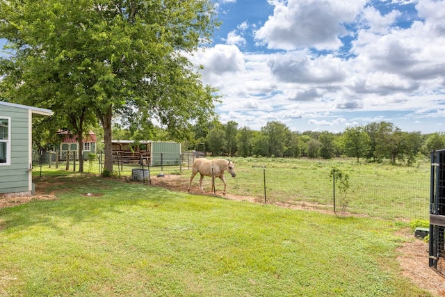 view of yard with a rural view and an outbuilding