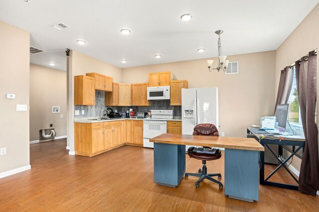 kitchen featuring a breakfast bar area, light hardwood / wood-style flooring, white appliances, decorative backsplash, and a chandelier