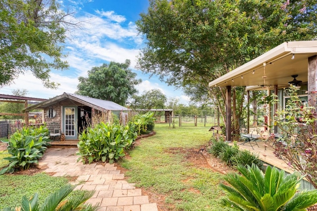 view of yard with a patio area, ceiling fan, and an outbuilding