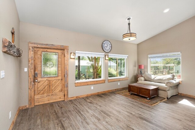 living area featuring lofted ceiling and hardwood / wood-style flooring