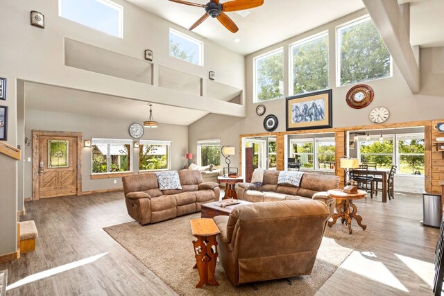 living room featuring ceiling fan, hardwood / wood-style floors, and high vaulted ceiling