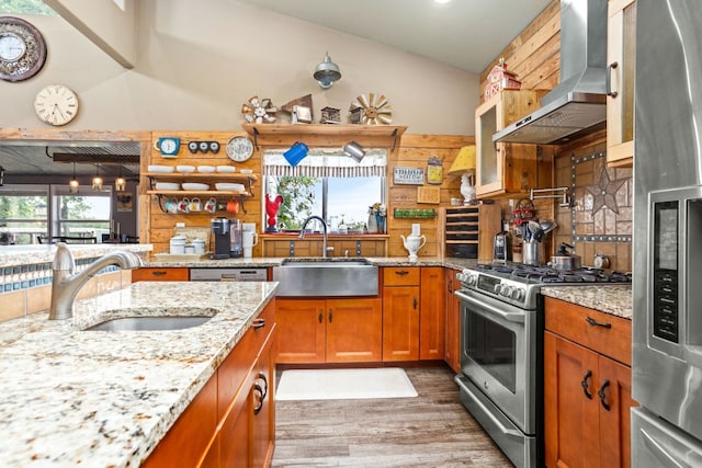 239 Dale Ranch Rd, Dale, TX 78616 - kitchen featuring appliances with stainless steel finishes, wall chimney range hood, wood finished floors, vaulted ceiling, and light stone countertops