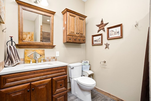 bathroom featuring hardwood / wood-style flooring, toilet, and vanity