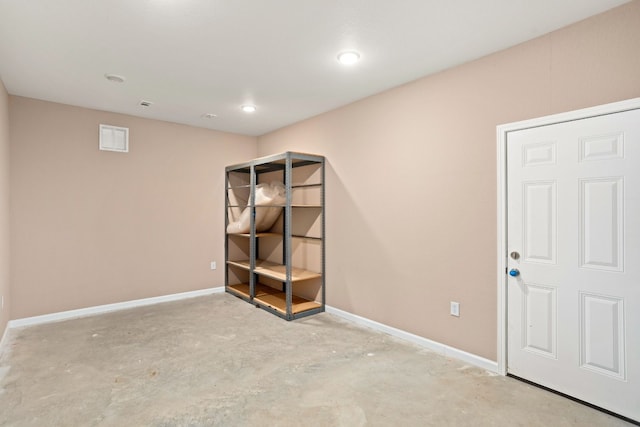 interior space featuring visible vents, baseboards, and unfinished concrete flooring