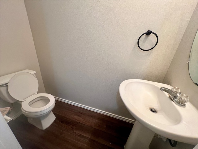 bathroom with wood-type flooring, sink, and toilet