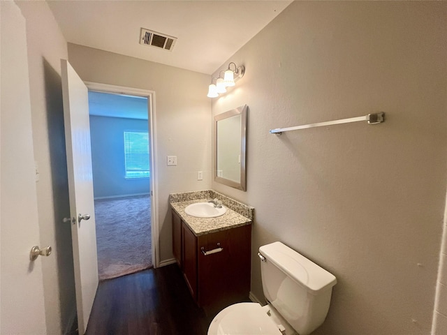 bathroom with vanity, hardwood / wood-style floors, and toilet