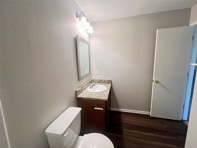 bathroom with vanity, toilet, and wood-type flooring