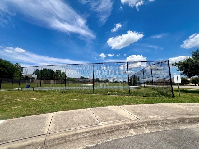 view of home's community with a yard and basketball hoop