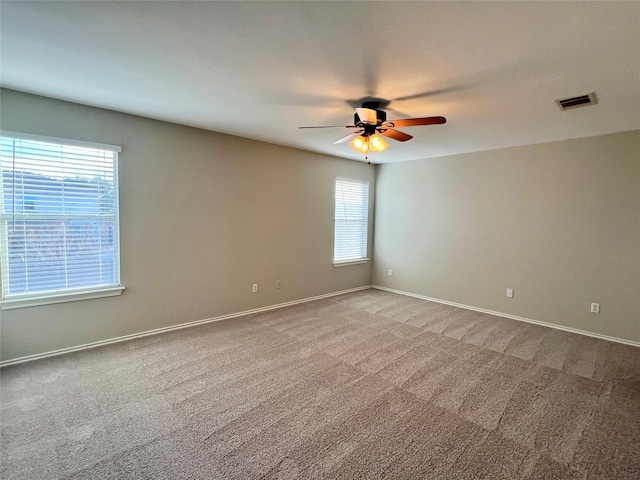 unfurnished room with ceiling fan, carpet floors, and a wealth of natural light