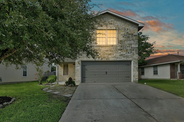 view of front of home with a garage and a yard